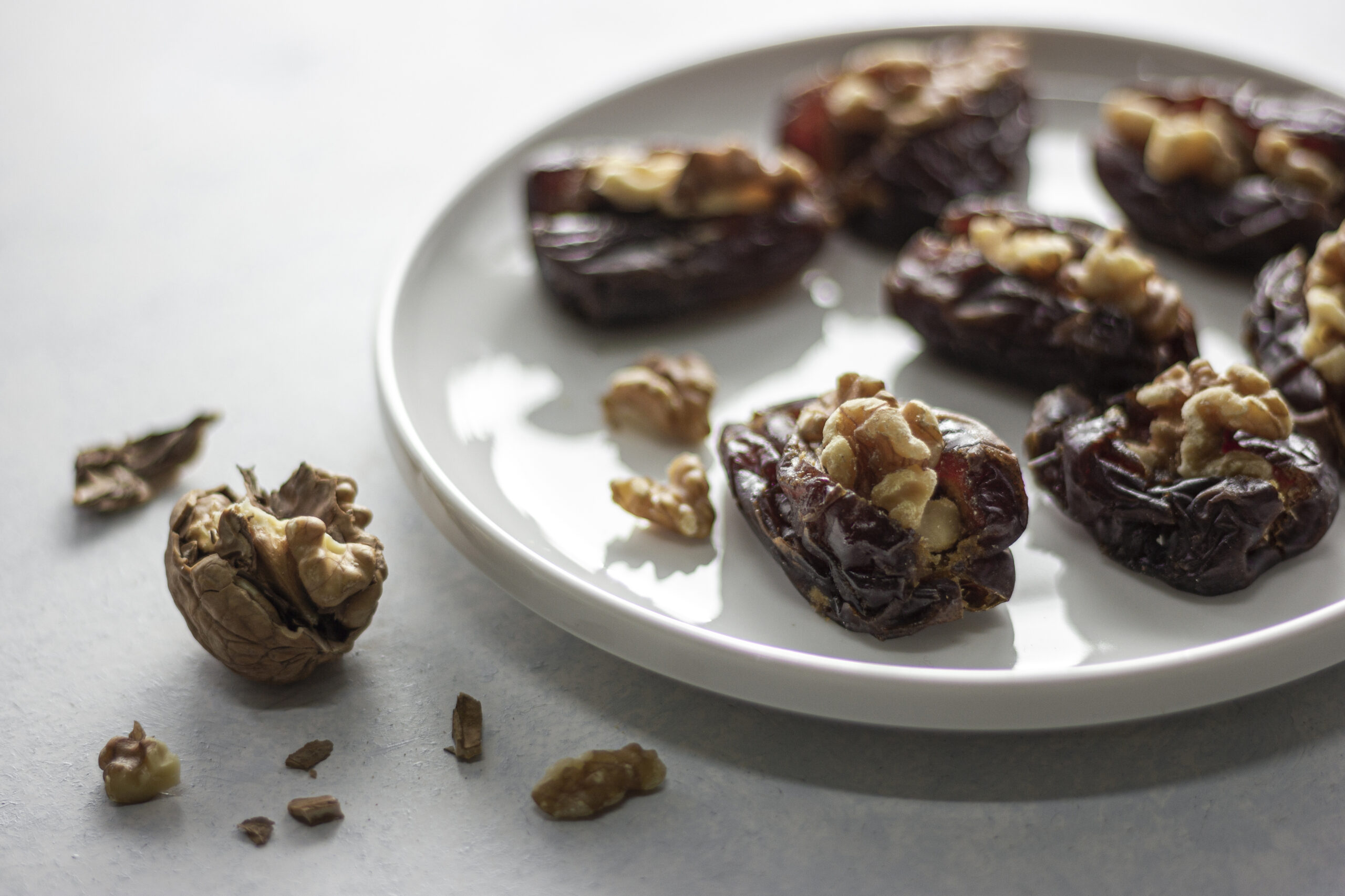 A plate of walnut-stuffed dates topped with pomegranate seeds